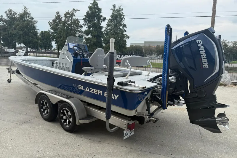 Slide: The Image of 2017 Blazer Bay 2420 boat on trailer, blue and white, parked outdoors. - 4