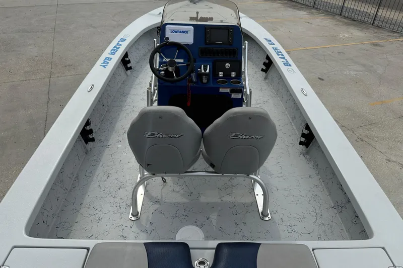 Slide: The Image of 2017 Blazer Bay 2420 boat with Evinrude engine on a trailer, parked outdoors. - 7