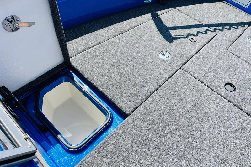 Slide: The Image of 2024 Ranger 620FS Pro boat interior with open storage compartment and carpeted flooring. - 18