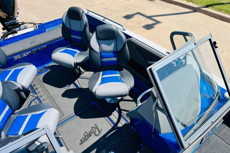 Slide: The Image of 2024 Ranger 620FS Pro boat interior with blue and gray seating, open windshield. - 38