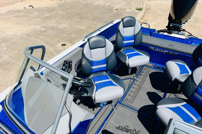 Slide: The Image of 2024 Ranger 620FS Pro boat interior with blue and gray seating, steering console, and deck. - 39