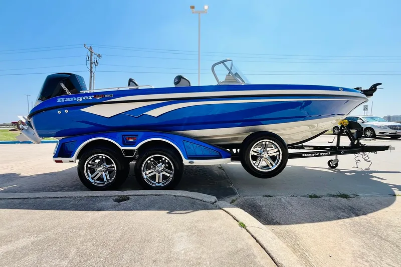 Slide: The Image of 2024 Ranger 620FS Pro boat in vibrant blue on a trailer, parked outdoors. - 5