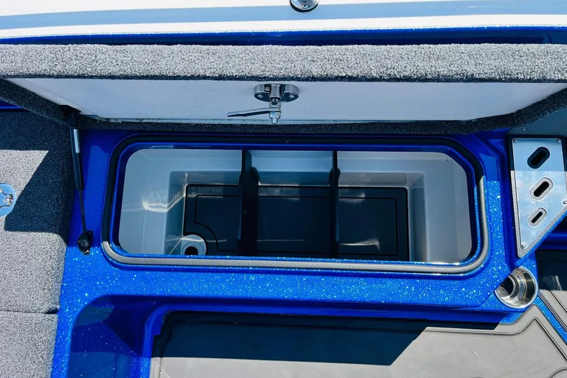 Slide: The Image of 2024 Ranger 620FS Pro boat storage compartment with blue trim and secure latch. - 58