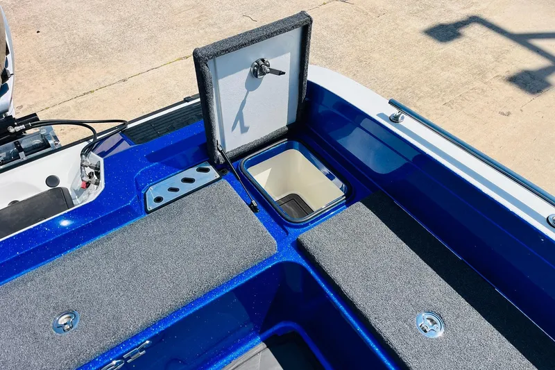 Slide: The Image of 2024 Ranger 620FS Pro boat with open storage compartment, blue finish, and carpeted surfaces. - 59