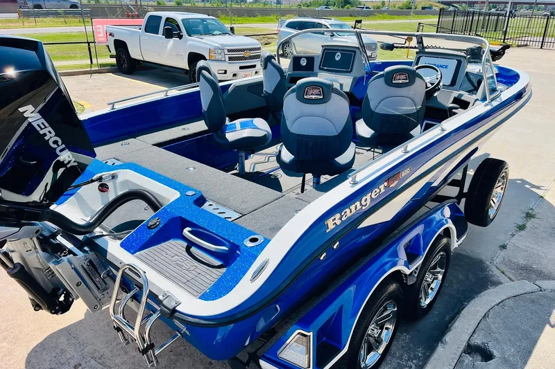 Slide: The Image of 2024 Ranger 620FS Pro boat with Mercury engine, parked beside a white truck. - 6