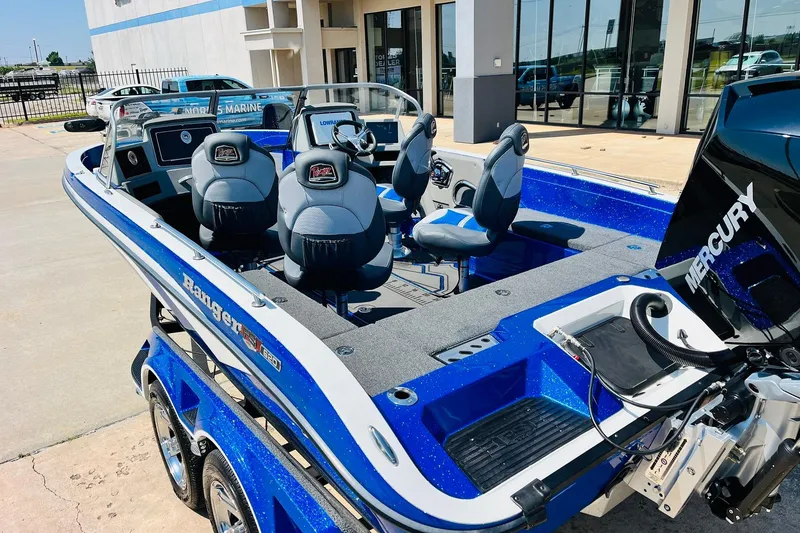 Slide: The Image of 2024 Ranger 620FS Pro boat with Mercury engine, blue and gray interior, parked outside a building. - 8