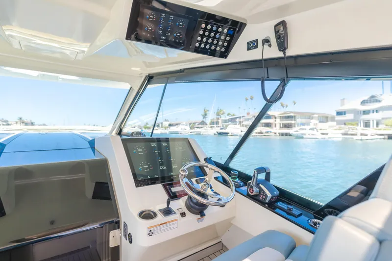 Slide: The Image of 2023 Scout 530 LXF yacht cockpit with modern controls and waterfront view. - 13
