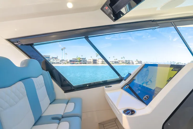 Slide: The Image of Interior view of 2023 Scout 530 LXF yacht with blue seating and navigation display. - 15