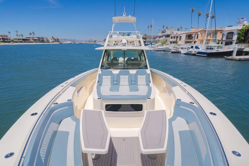 Slide: The Image of 2023 Scout 530 LXF luxury boat docked in a scenic marina setting. - 17