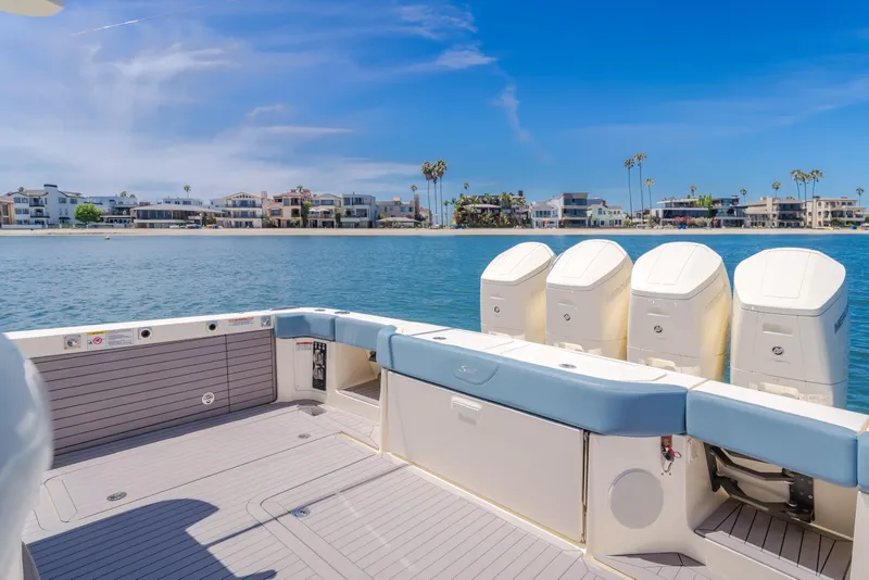 Slide: The Image of 2023 Scout 530 LXF boat with four engines, docked near waterfront homes. - 18