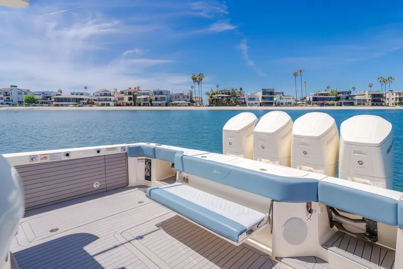 Slide: The Image of 2023 Scout 530 LXF boat with four engines, docked near waterfront homes. - 19