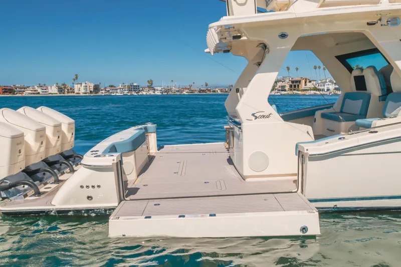 Slide: The Image of 2023 Scout 530 LXF luxury boat with spacious deck and powerful engines on clear water. - 23