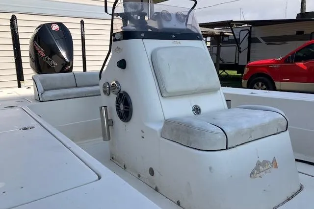 Slide: The Image of 2007 Dutch Sterling 22 boat with seating and outboard motor, parked near a red vehicle. - 8