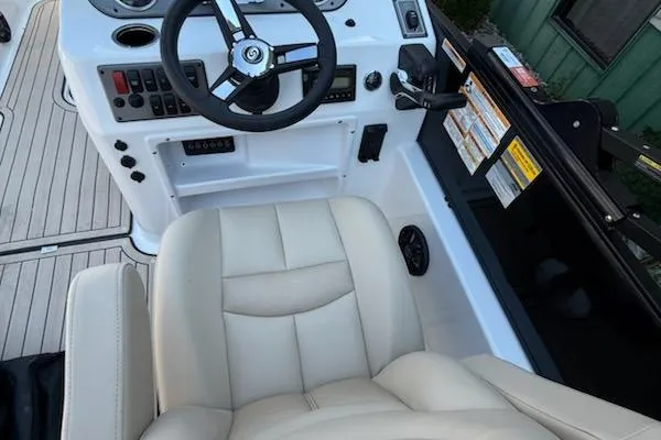 Slide: The Image of 2026 Hurricane FD198RE-OB boat cockpit with steering wheel and beige seating. - 7