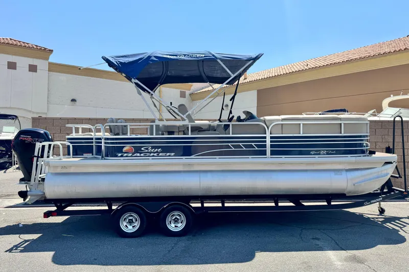 The Image of 2021 Sun Tracker SportFish 22 DLX pontoon boat with canopy on trailer. - 0