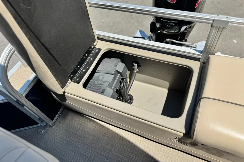 Slide: The Image of 2021 Sun Tracker SportFish 22 DLX boat storage compartment with open lid and visible battery. - 19