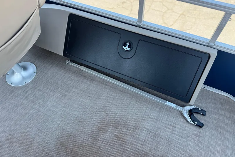 Slide: The Image of 2021 Sun Tracker SportFish 22 DLX interior with storage compartment and grabber tool. - 20