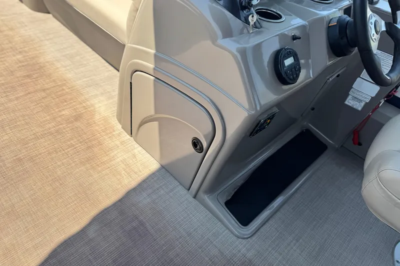 Slide: The Image of 2021 Sun Tracker SportFish 22 DLX boat interior with steering console and storage compartment. - 26