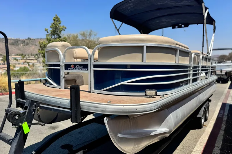 Slide: The Image of 2021 Sun Tracker SportFish 22 DLX pontoon boat on trailer, parked outdoors. - 3