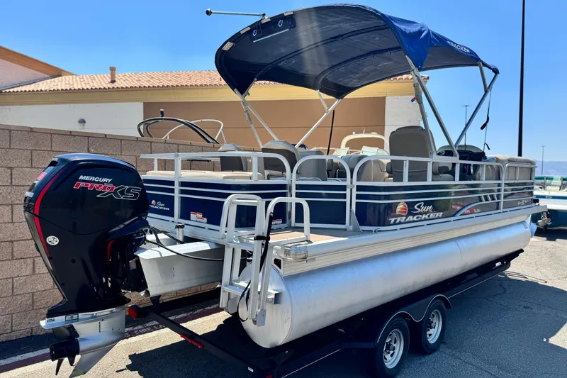 Slide: The Image of 2021 Sun Tracker SportFish 22 DLX pontoon boat with Mercury Pro XS engine, parked on trailer. - 7