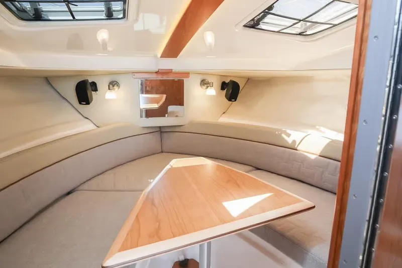 Slide: The Image of 2026 Cutwater C-248 Coupe interior cabin with seating and wooden table. - 12