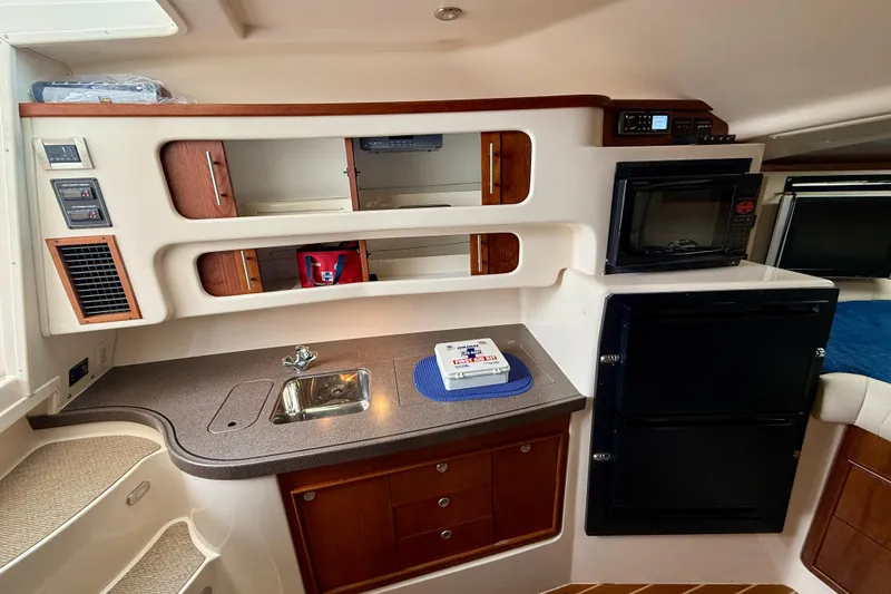 Slide: The Image of 2008 Grady-White Express 360 interior with kitchenette, sink, microwave, and storage cabinets. - 12