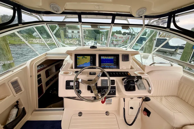 Slide: The Image of 2008 Grady-White Express 360 helm with navigation screens and steering wheel, docked by the water. - 3