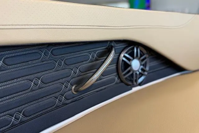 Slide: The Image of 2024 Sea Ray SPX 210 interior detail with speaker and handle, featuring elegant stitching. - 17