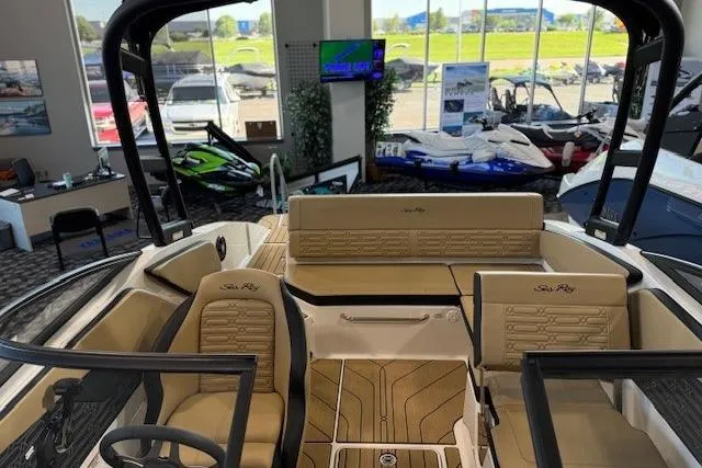 Slide: The Image of 2024 Sea Ray SPX 210 boat interior with tan seating, displayed in a showroom. - 19