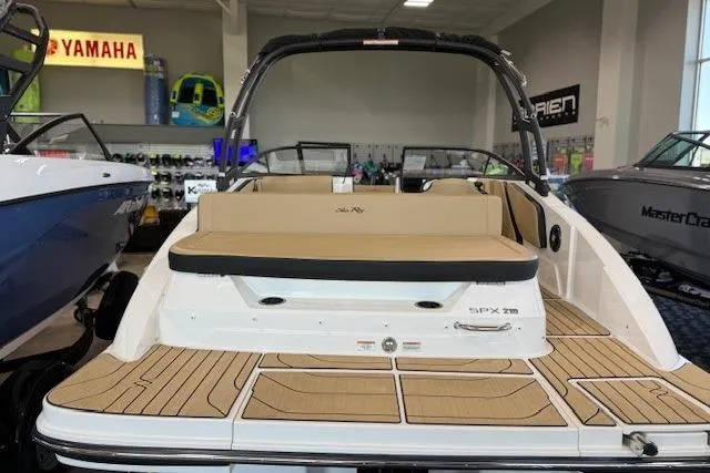 Slide: The Image of 2024 Sea Ray SPX 210 boat interior with tan seating and teak flooring. - 7