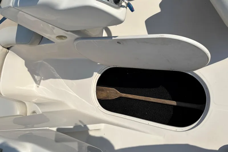 Slide: The Image of Open storage compartment in 2006 Starcraft C-Star 1800 I/O boat with wooden paddle. - 13