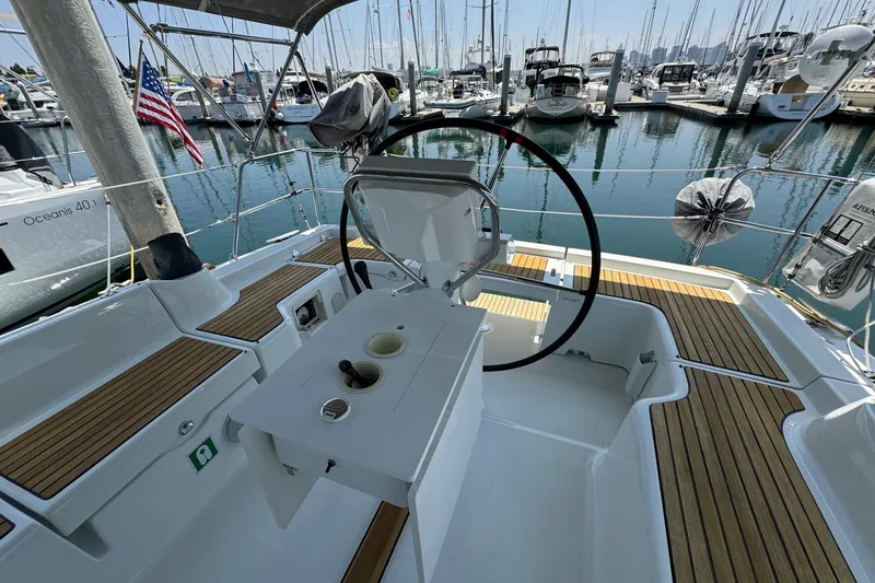 Slide: The Image of Cockpit of 2017 Beneteau Oceanis 37 sailboat docked in marina, featuring steering wheel and seating. - 19