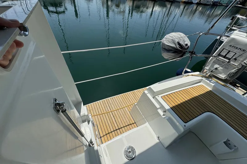 Slide: The Image of Beneteau Oceanis 37 sailboat deck, 2017 model, with teak flooring and marina view. - 22
