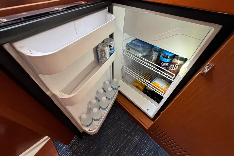 Slide: The Image of Refrigerator inside 2017 Beneteau Oceanis 37 yacht, stocked with drinks and food items. - 34