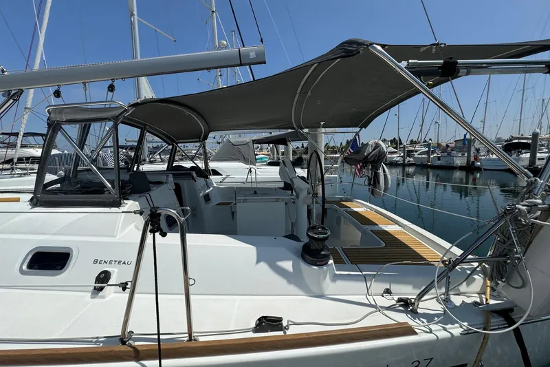 Slide: The Image of 2017 Beneteau Oceanis 37 sailboat docked at marina, featuring shaded cockpit area. - 7