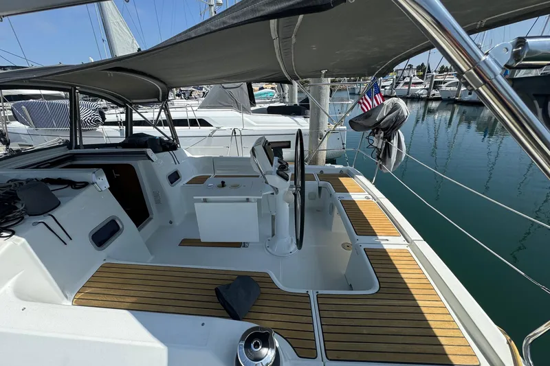 Slide: The Image of 2017 Beneteau Oceanis 37 sailboat cockpit with teak flooring and marina view. - 9
