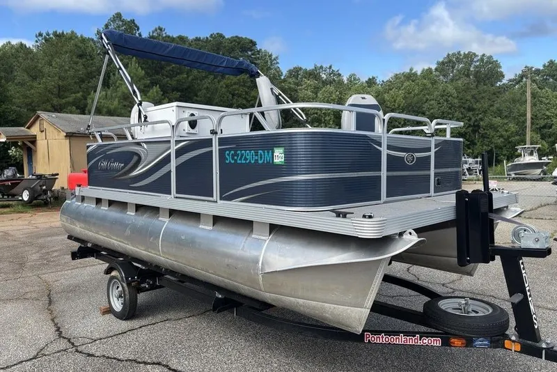 Slide: The Image of 2020 Apex Gillgetter 7515 Tiller pontoon boat on trailer, parked outdoors. - 7