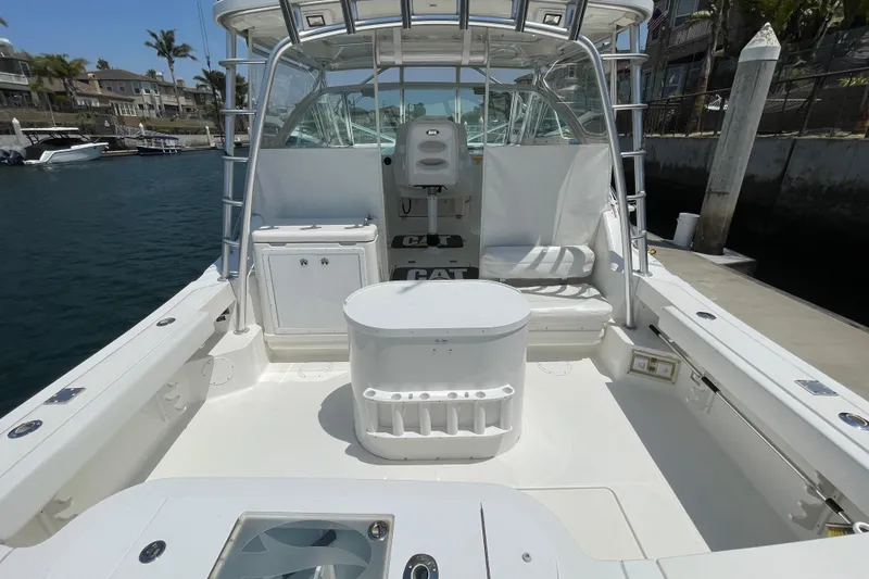 Slide: The Image of 2005 Rampage 33 Express boat interior with seating and storage, docked in a marina. - 11