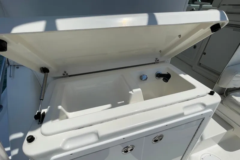 Slide: The Image of Open storage compartment on 2005 Rampage 33 Express boat, featuring a built-in sink. - 17