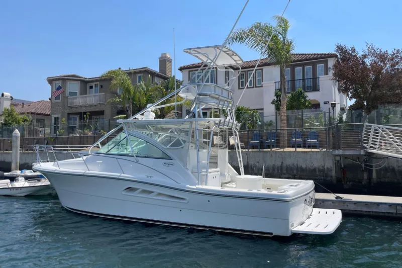 Slide: The Image of 2005 Rampage 33 Express boat docked near waterfront homes. - 2