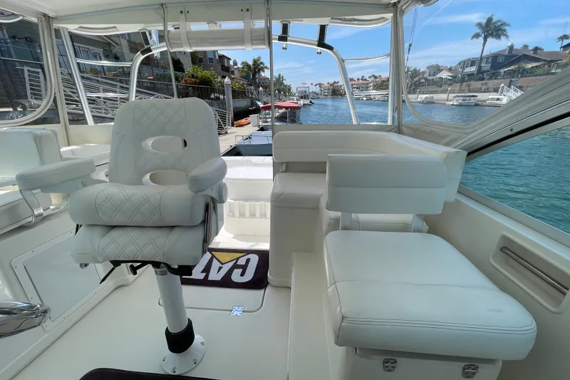 Slide: The Image of 2005 Rampage 33 Express boat interior with white seating, overlooking a scenic waterfront. - 23