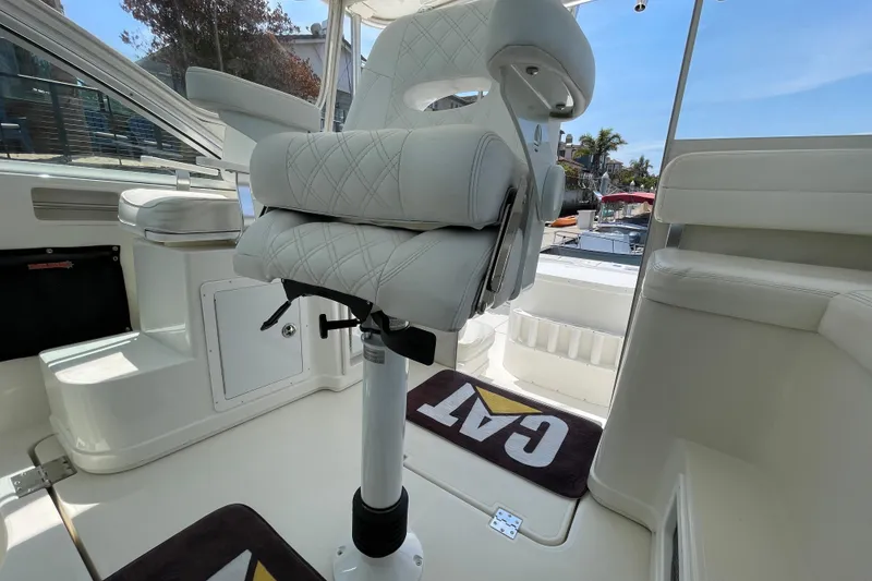 Slide: The Image of Captain's chair on 2005 Rampage 33 Express boat, featuring white upholstery and CAT mat. - 25