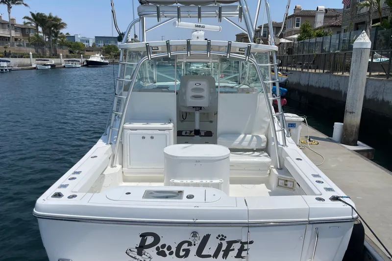 Slide: The Image of 2005 Rampage 33 Express boat docked, featuring spacious deck and fishing equipment. - 3