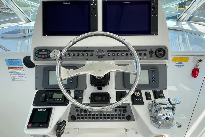 Slide: The Image of Control panel of a 2005 Rampage 33 Express boat with steering wheel and navigation screens. - 31