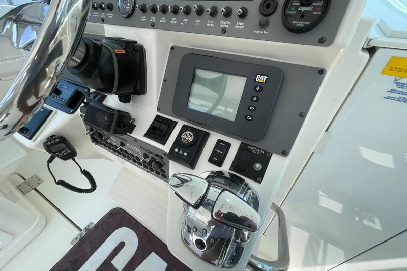 Slide: The Image of Control panel of a 2005 Rampage 33 Express boat with steering wheel and navigation equipment. - 34