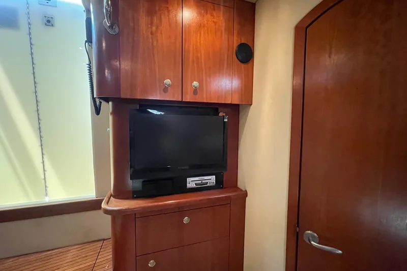 Slide: The Image of Interior of 2005 Rampage 33 Express with wooden cabinets and a TV setup. - 39