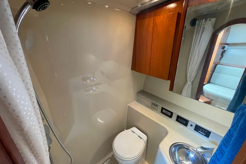 Slide: The Image of 2005 Rampage 33 Express yacht bathroom with shower, toilet, sink, and wooden cabinetry. - 41