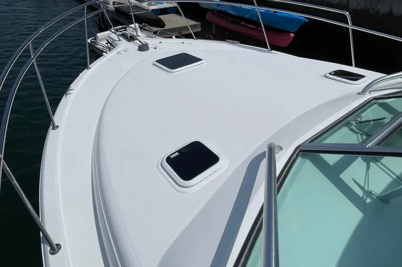 Slide: The Image of 2005 Rampage 33 Express boat deck with hatches, docked by the water. - 43