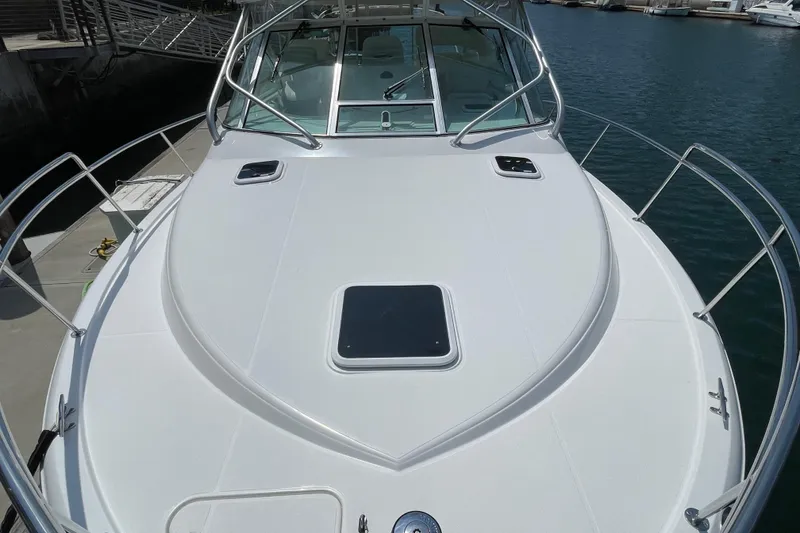 Slide: The Image of 2005 Rampage 33 Express boat deck with sleek design and railing, docked at marina. - 46