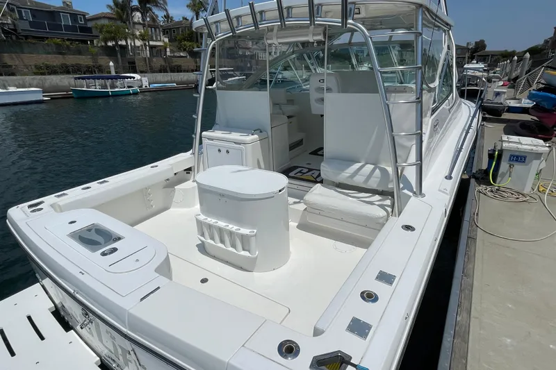 Slide: The Image of 2005 Rampage 33 Express boat docked, featuring spacious deck and seating area. - 5